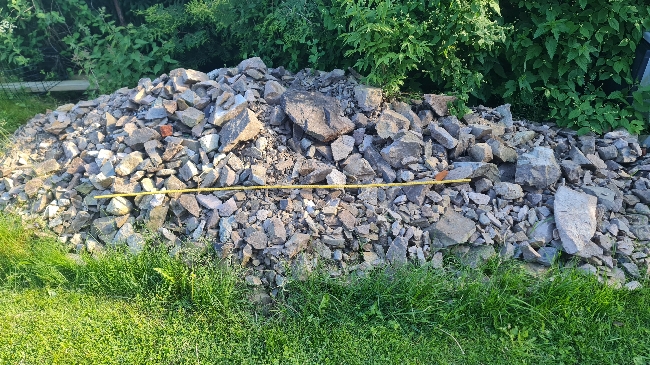 Frakte (trillebår) ca 0,6 kbm steinmasse ca 75 m ned til vei