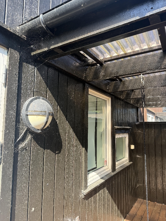 Fasadevask av bakside av rekkehus og overbygd terrasse