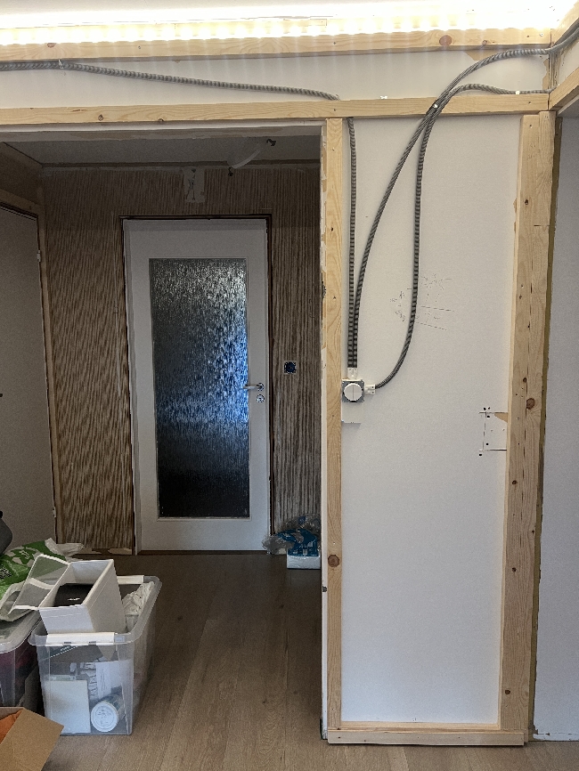 Ferdigstille montering av veggpanel og lister i stue